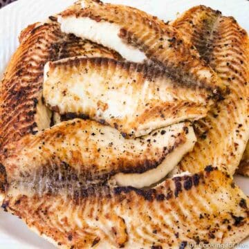 pile of grilled tilapia on white plate
