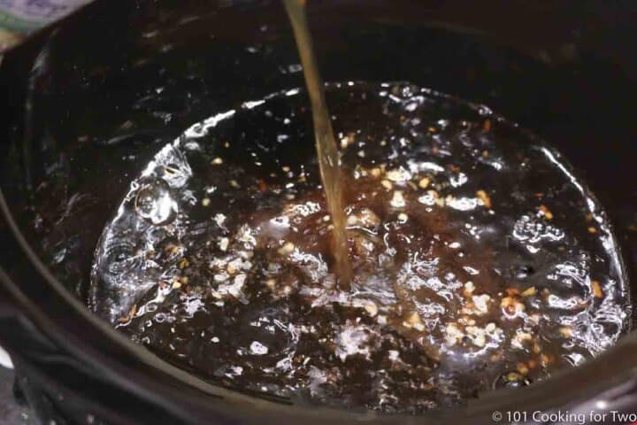 pouring beef broth into crock pot