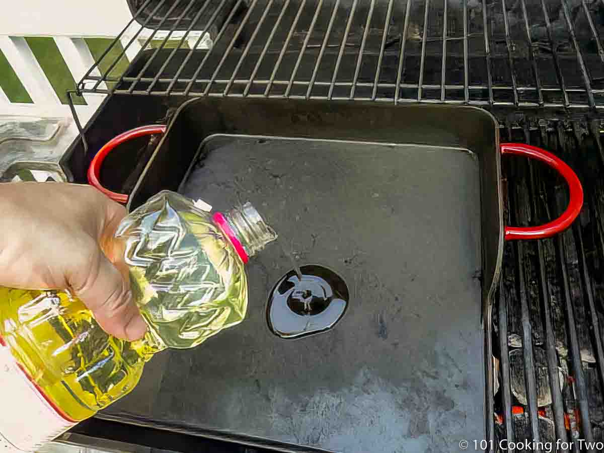 pouring oil on griddle on grill.