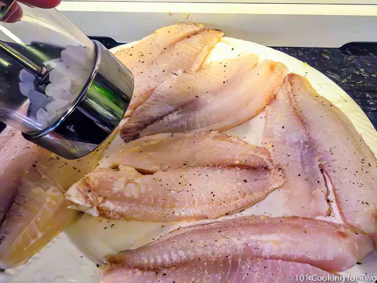 salting tilapia on white plate.