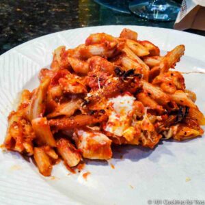 Baked chicken ziti on a white plate.