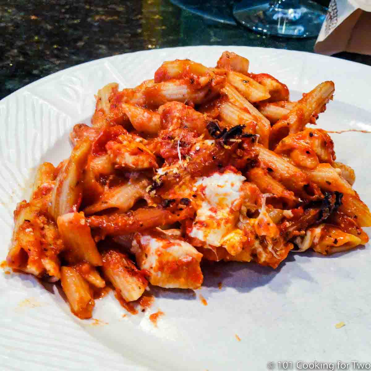 Baked chicken ziti on a white plate.