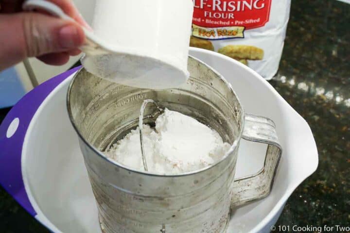 adding flour to sifter