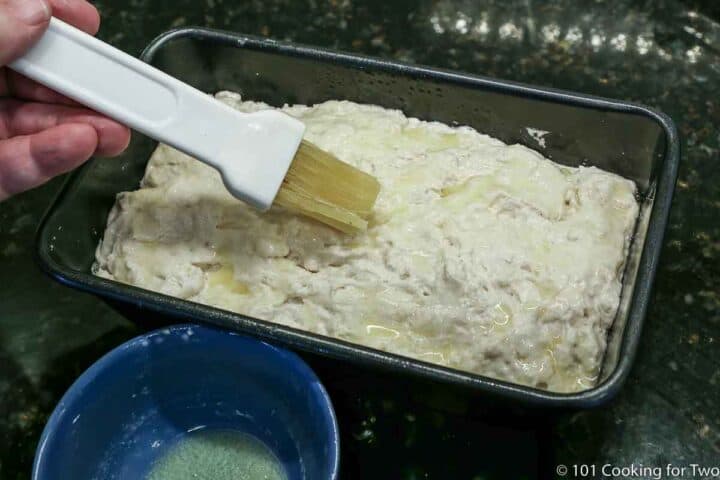 brushing top of loaf with melted butter