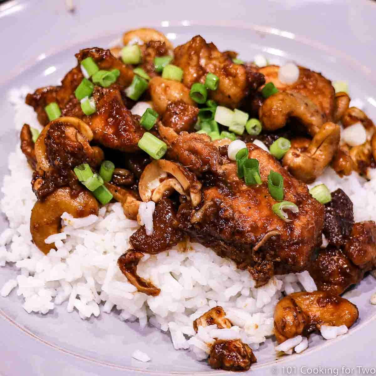 cashew chicken on with rice on a gray plate.