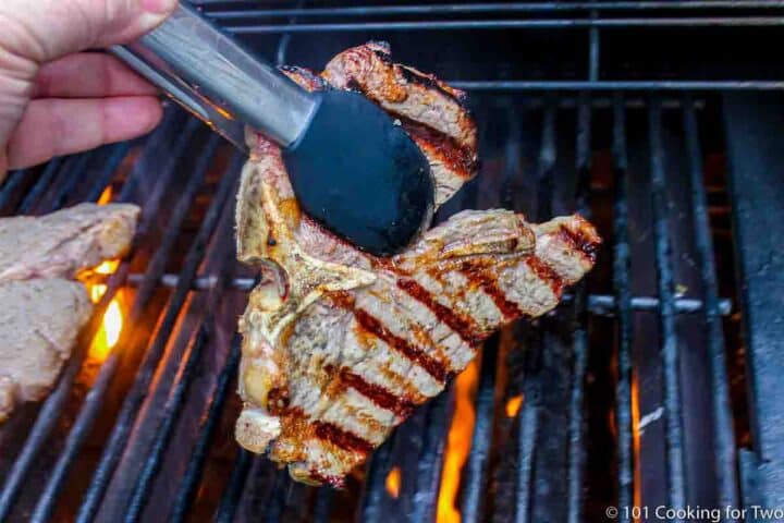 flipping a porterhouse steak on the grill