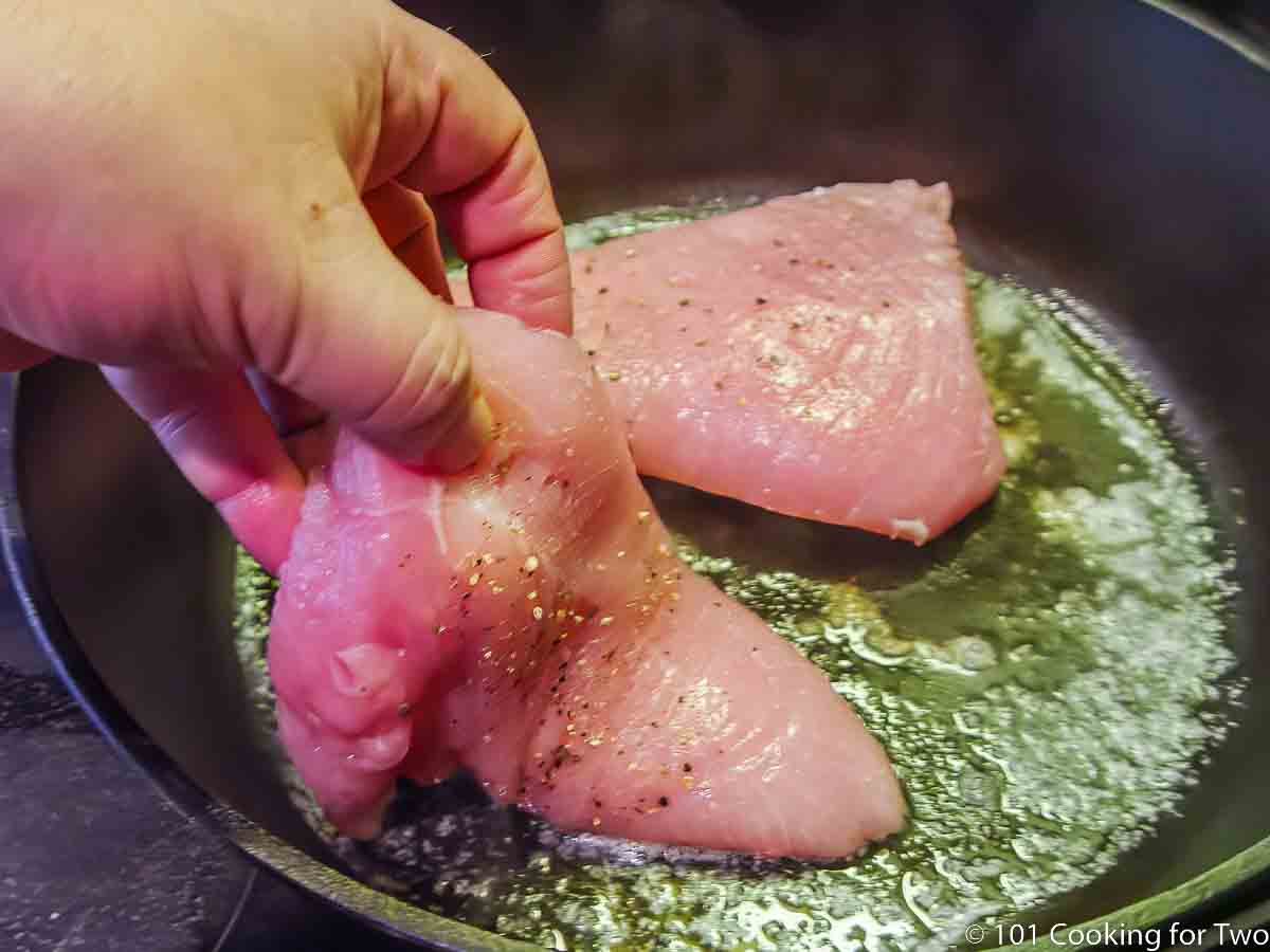 laying turkey tenderloins in pan with hot butter.