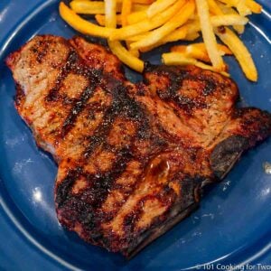 porterhouse steak with fries on blue plate