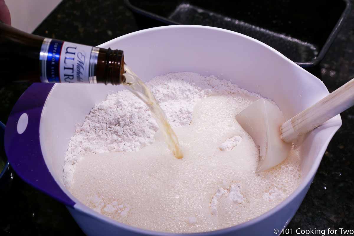 pouring beer into flour mixture.
