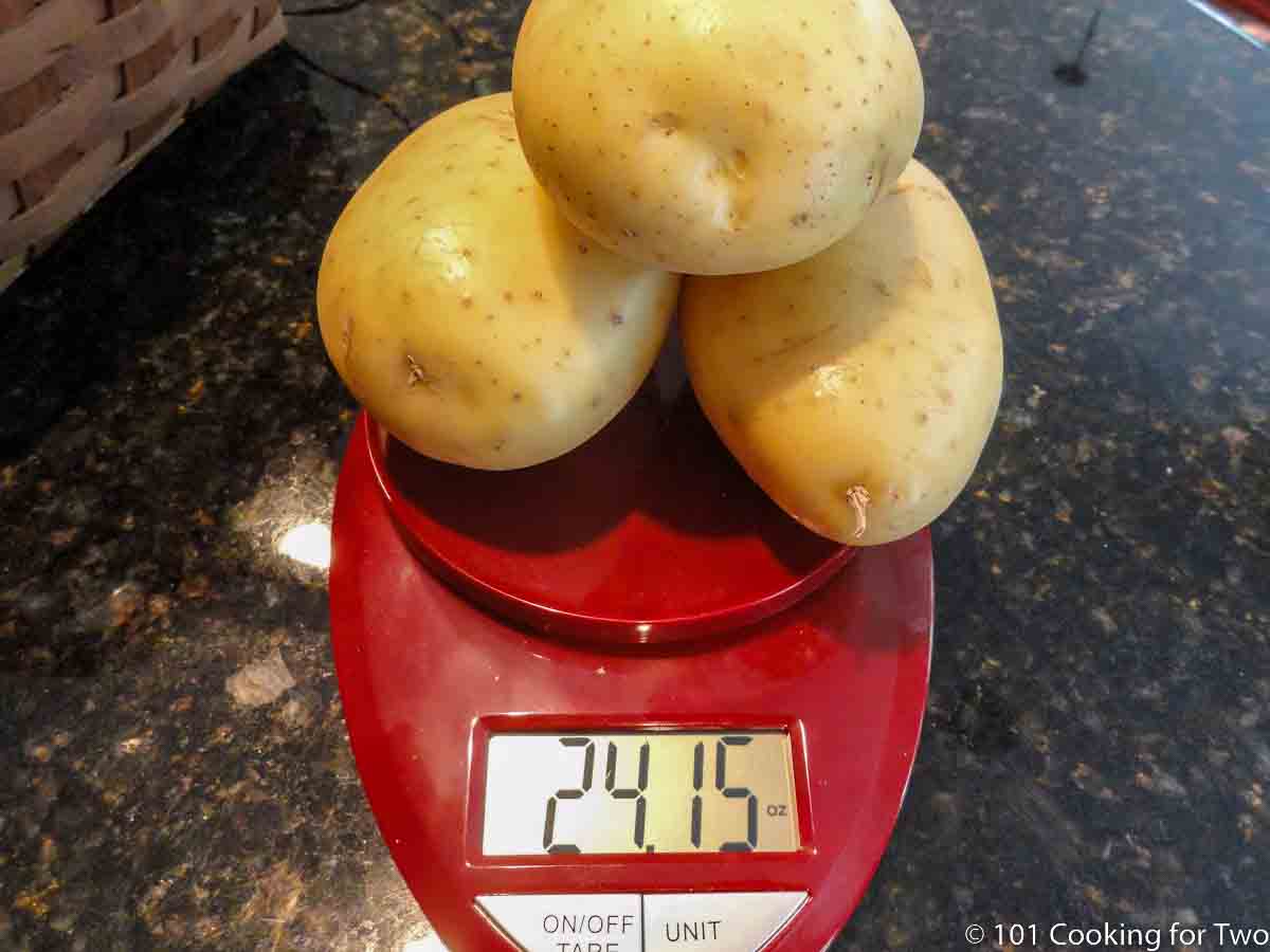 three Yukon Gold potatoes on a scale.