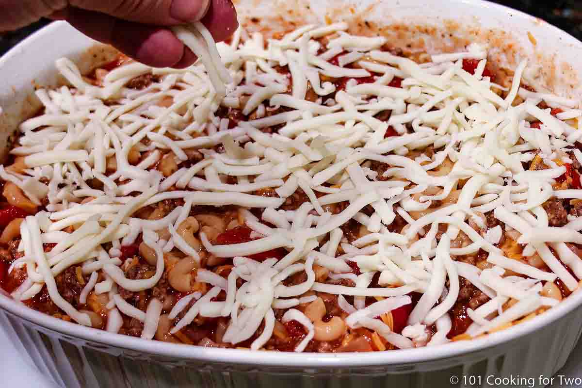 topping goulash with cheese.