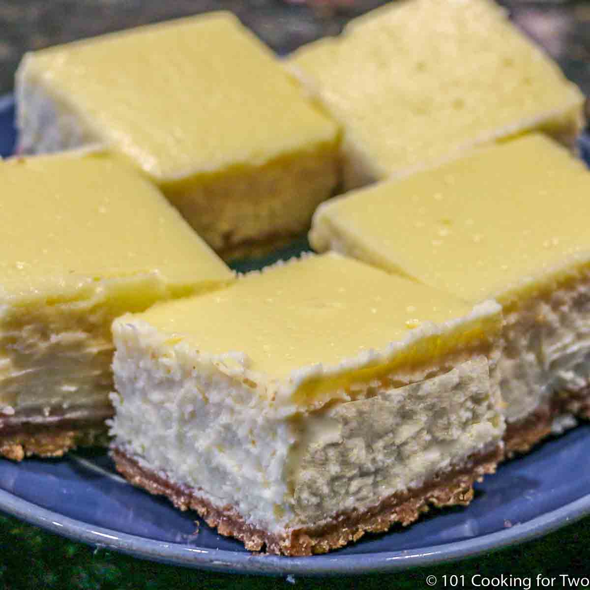 Cheesecake bars on a blue plate.