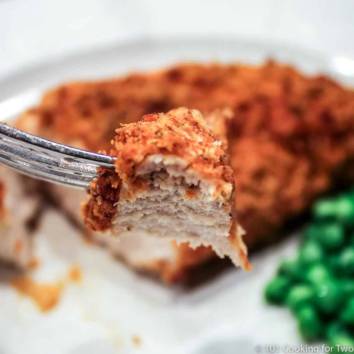 Oven Baked Parmesan Paprika Skinless Boneless Chicken Breast from 101 Cooking For Two bite of Parmesan crusted chicken on a fork