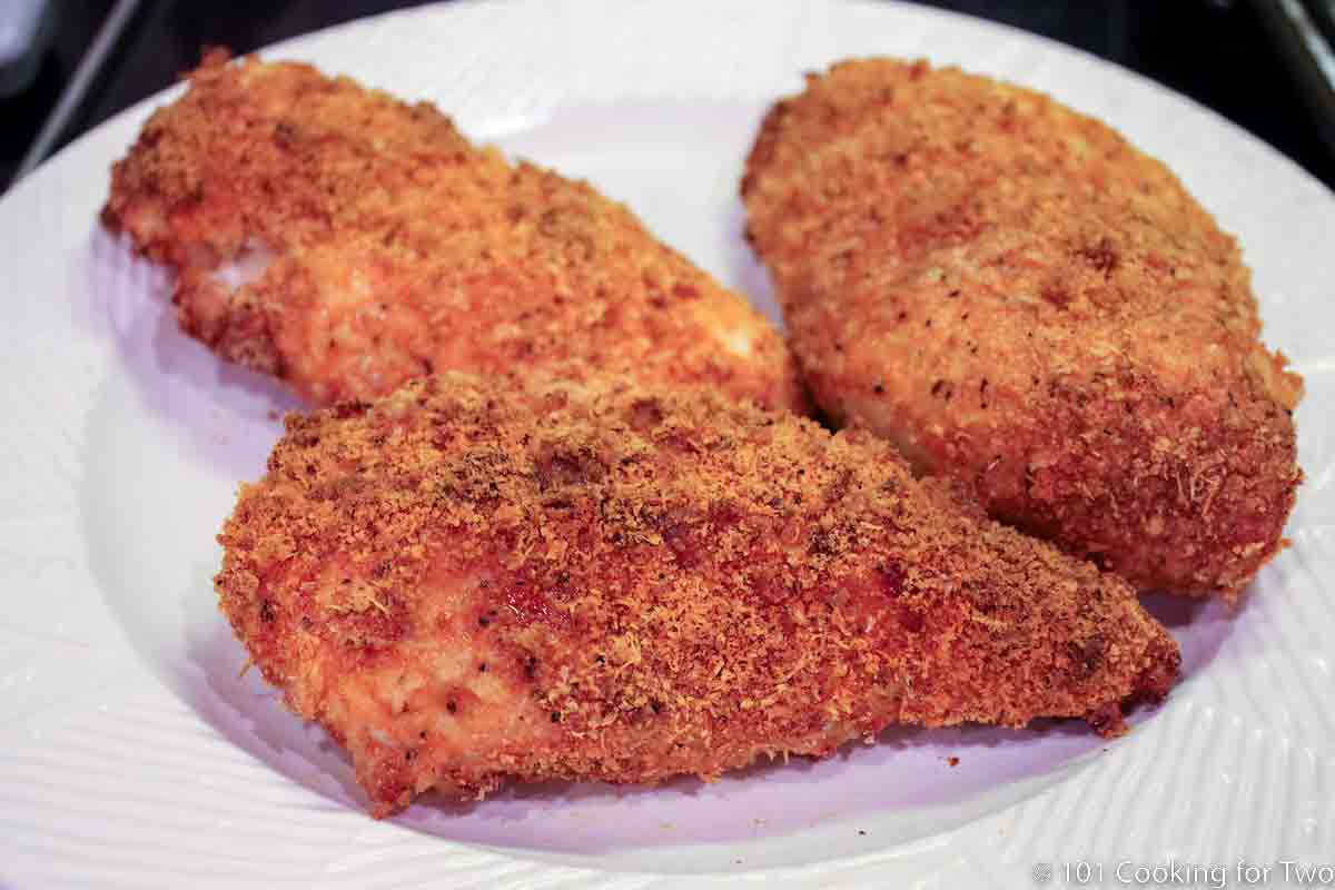 parmesan crusted chicken on a white plate.