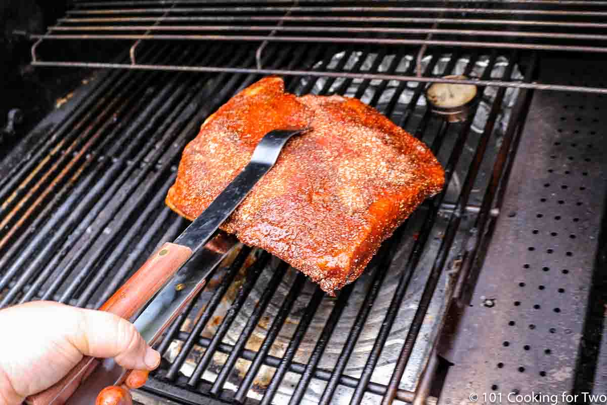 placing brisket on indirect side of the grill.