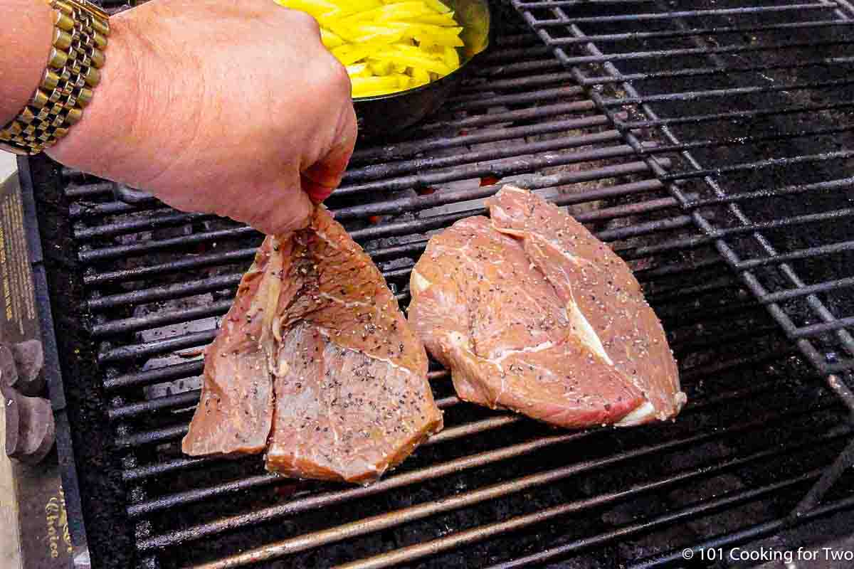 sirloin steaks going onto the grill.