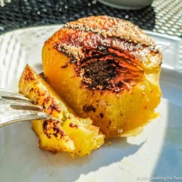 cut grilled peach on a white plate.