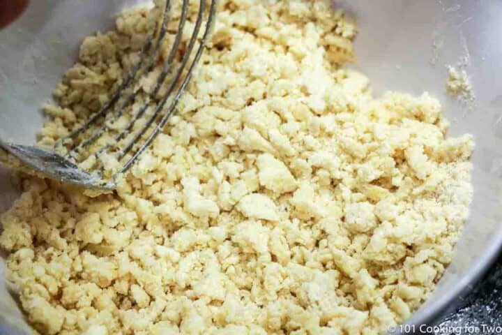 cutting butter into crumbly dough