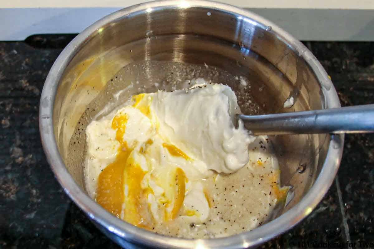 mixing dressing in a metal bowl