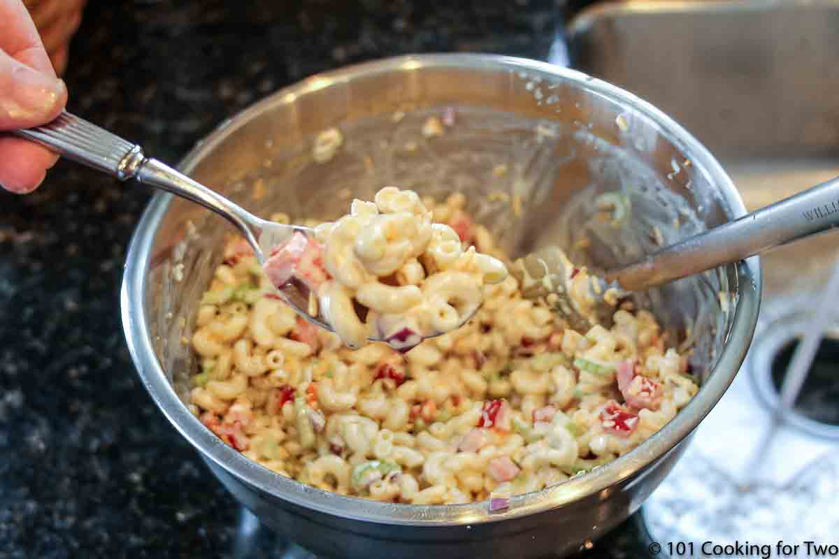 mixing macaroni salad in metal bowl