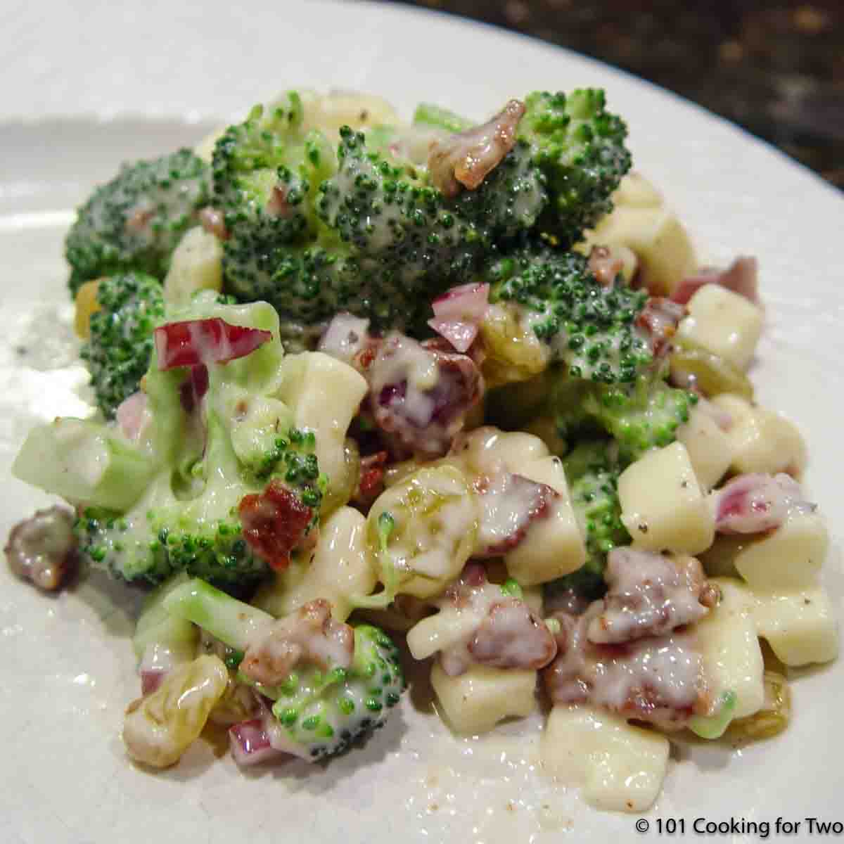 broccoli salad with bacon on white plate.