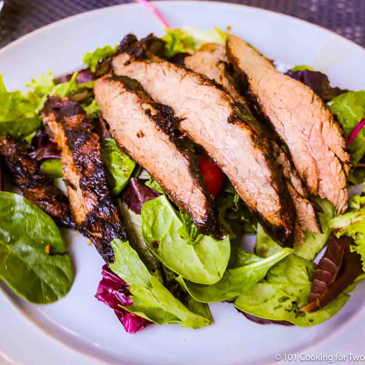 grilled flank steak on a salad.