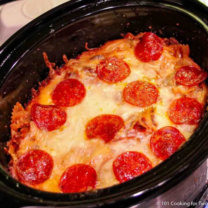 Cooked pizza casserole in a crock pot.