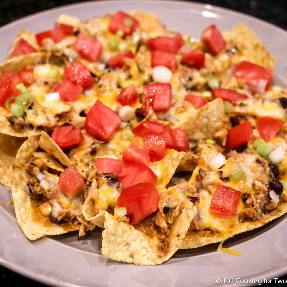 Fiesta chicken as nachos with tomato and cheese topping.
