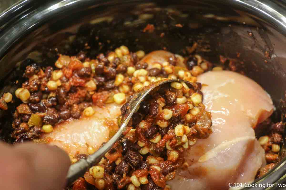 covering chicken breast with bean mixture.