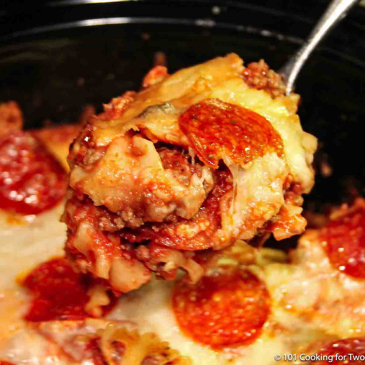 pizza casserole in a large spoon over a crock pot.