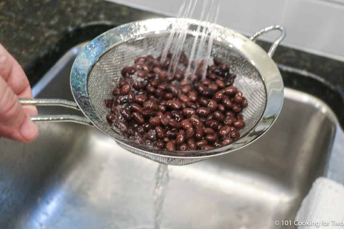 rinsing black beans under running water.