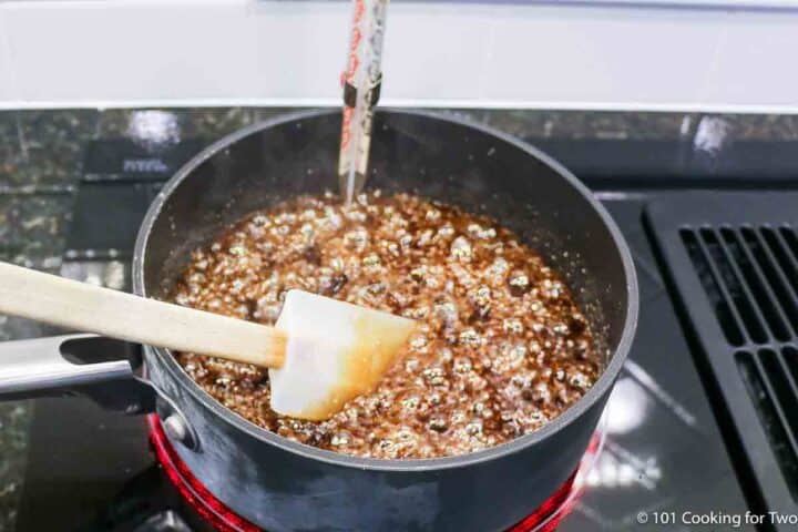 making caramel in a sauce pan with a candy thermometer.