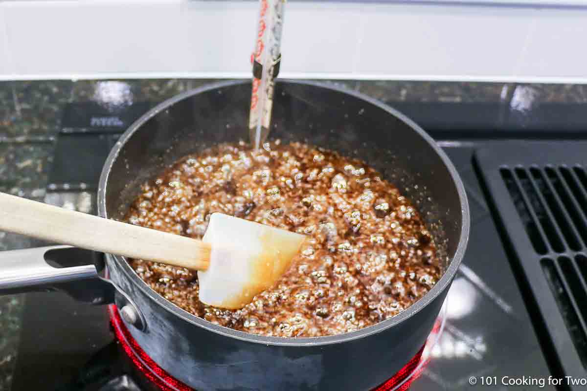 making caramel in a sauce pan with a candy thermometer.