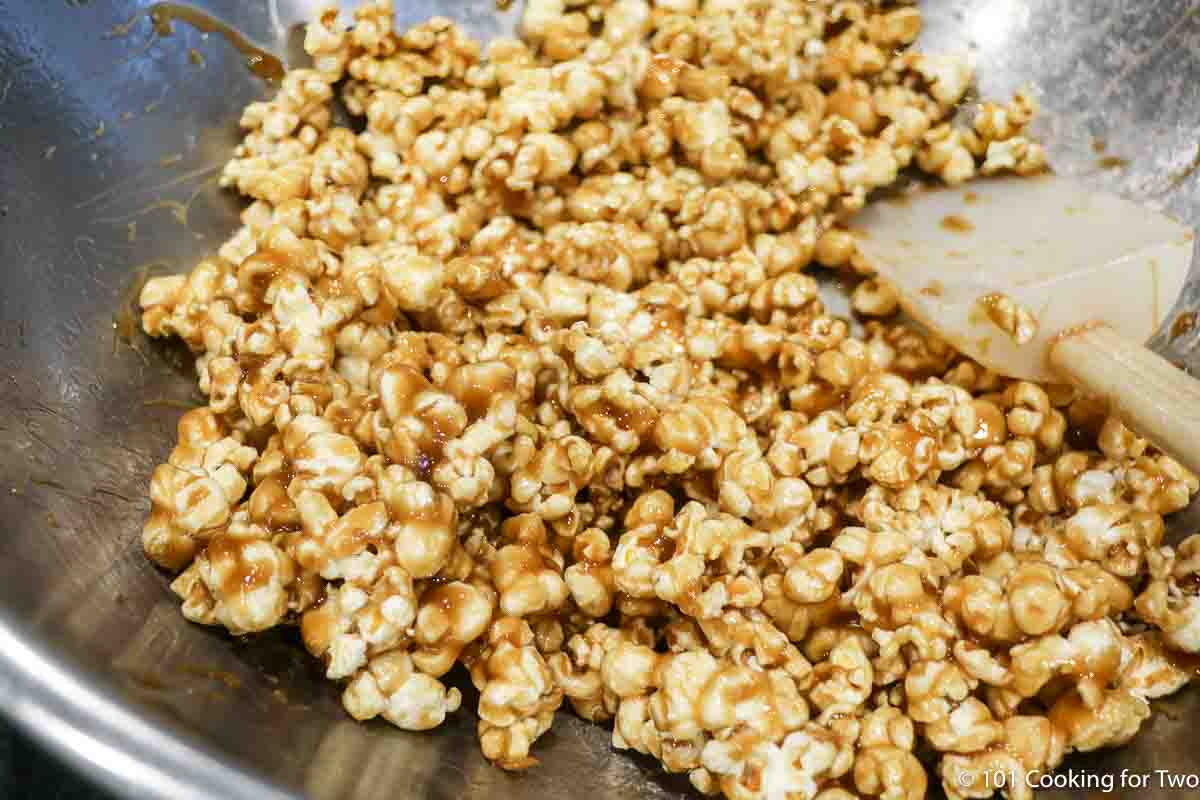 mixing caramel into the popcorn.