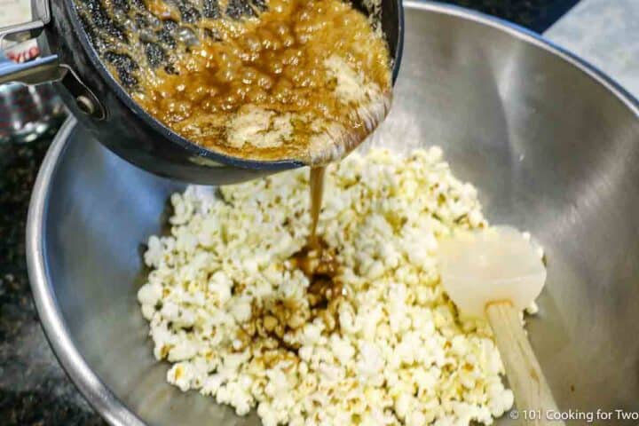 pouring caramel into the popcorn.