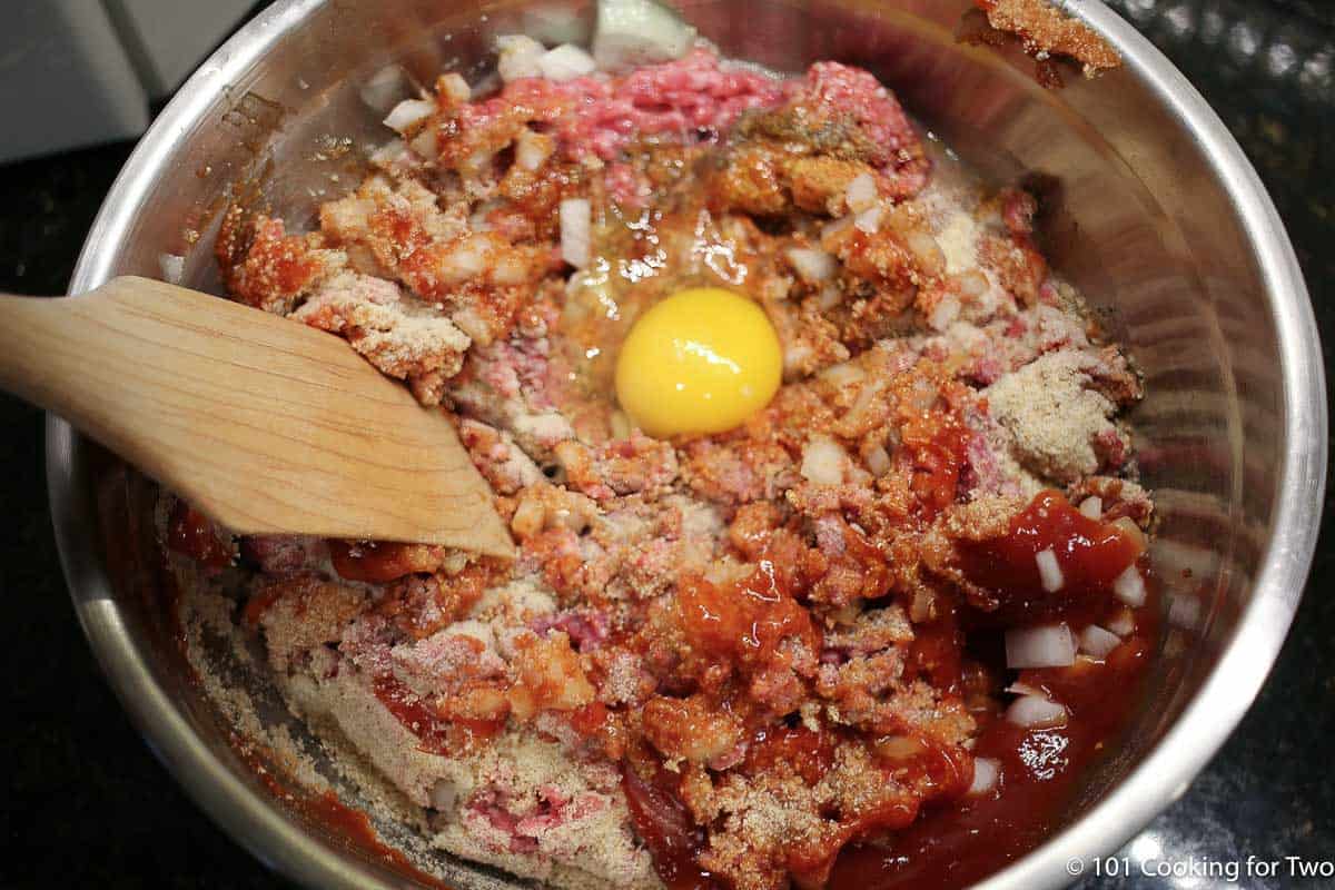 Mixing egg into the meat .