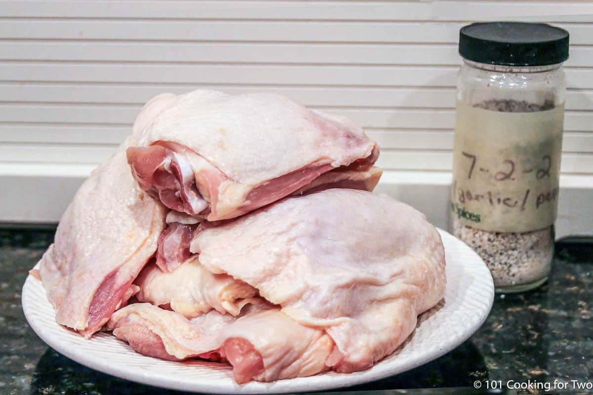 Raw chicken thighs with seasoning.