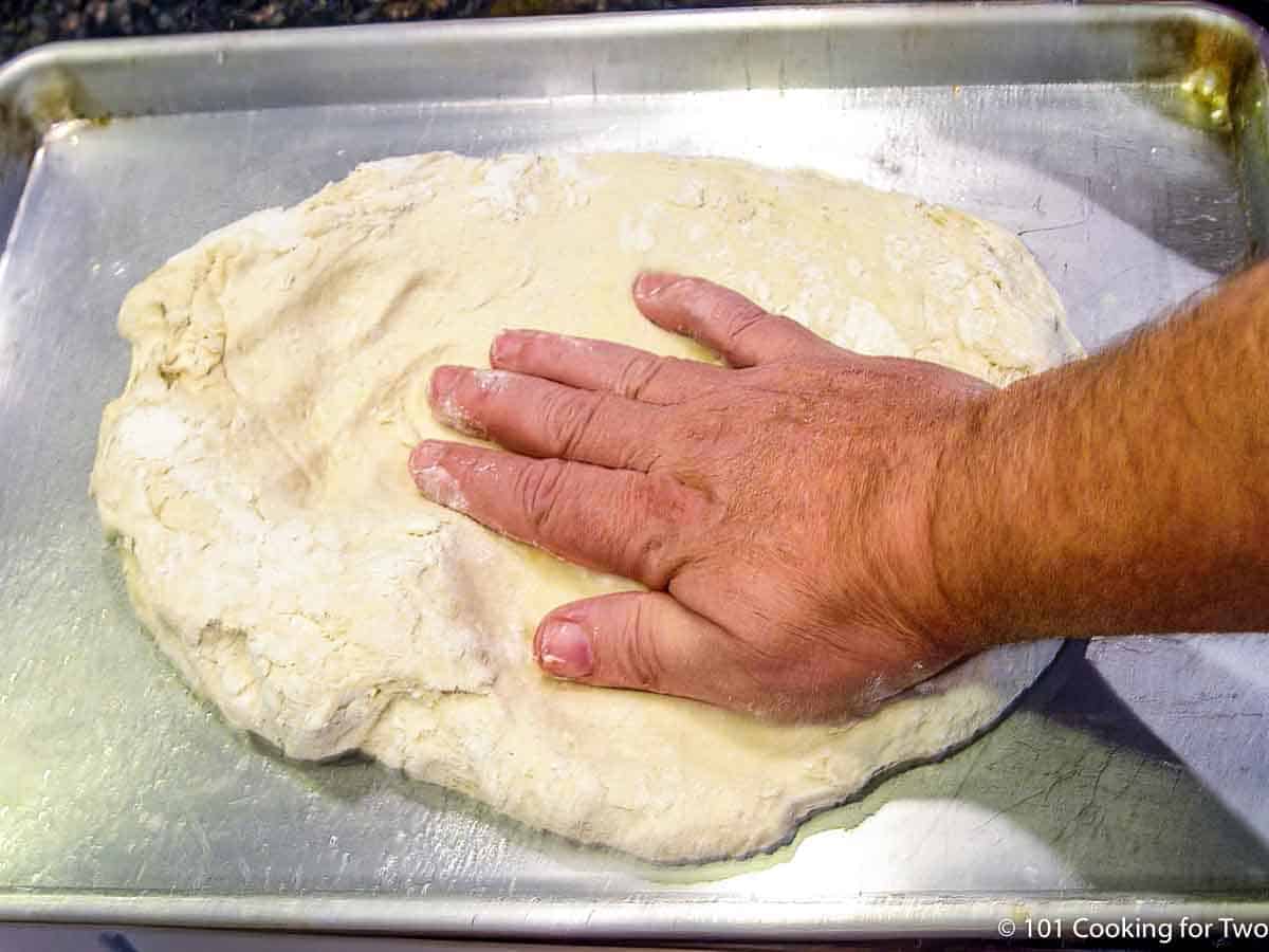 making out pizza dough on a sheet pan.