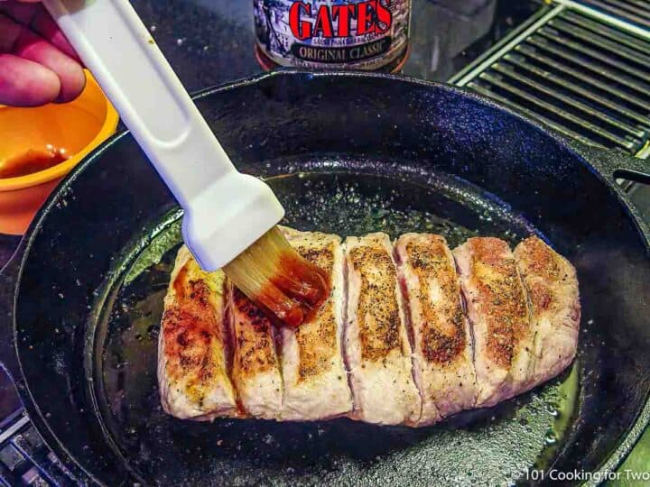 brushing seared boneless ribs with BBQ sauce.