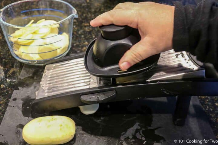 slicing pealed potatoes with a manoline.