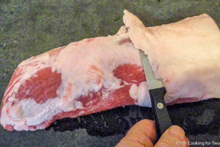 trimming fat pad from boneless pork ribs.