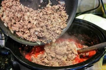 adding browned meat to crock pot.