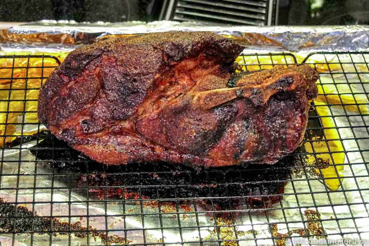 cooked pork butt out of the oven on a tray.