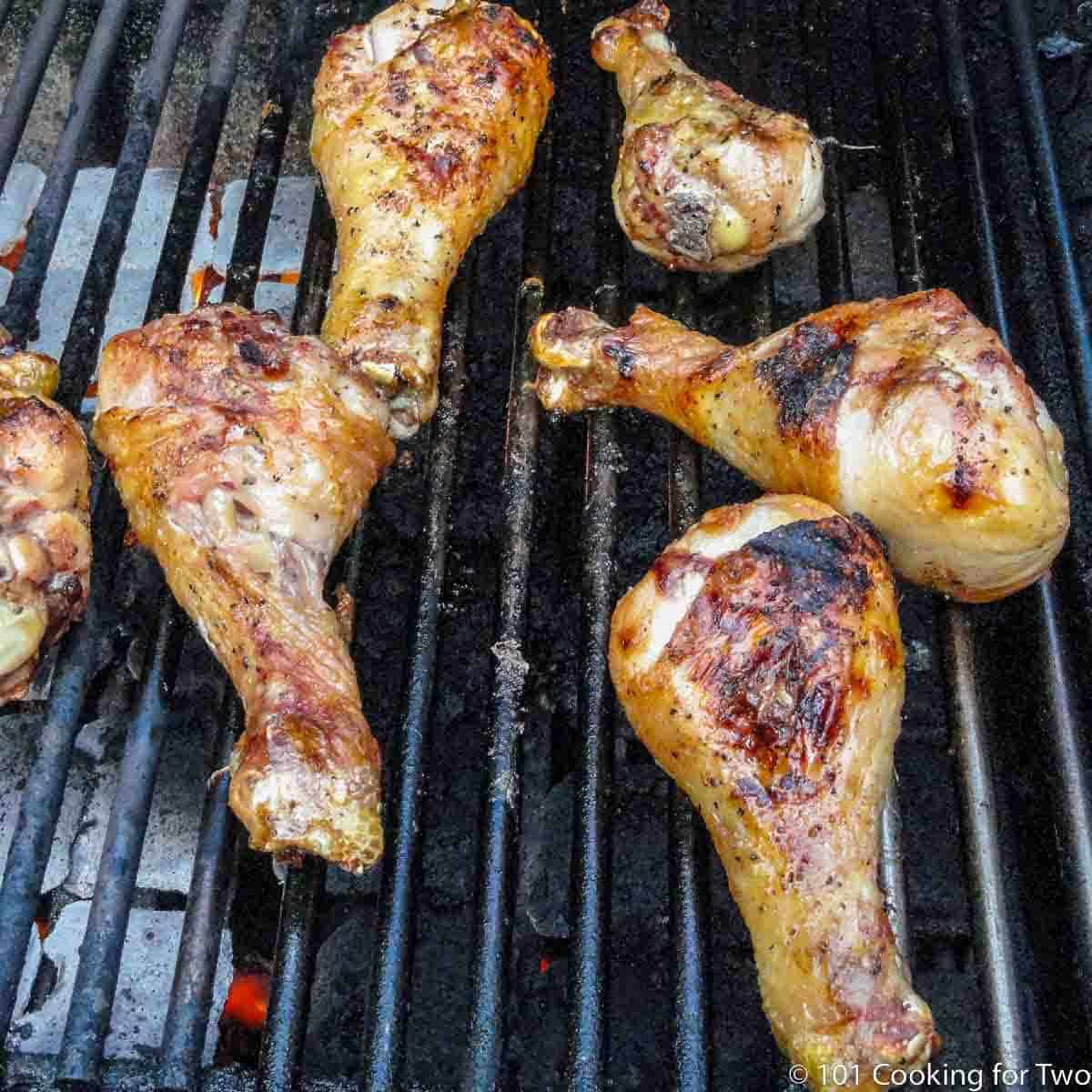 chicken drumsticks cooking on the grill.