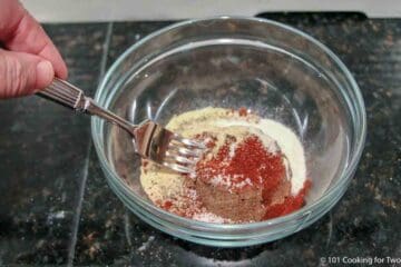 mixing dry rub in a small glass bowl.