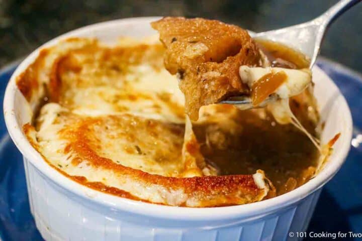 spoon full of French onion soup with cheese.