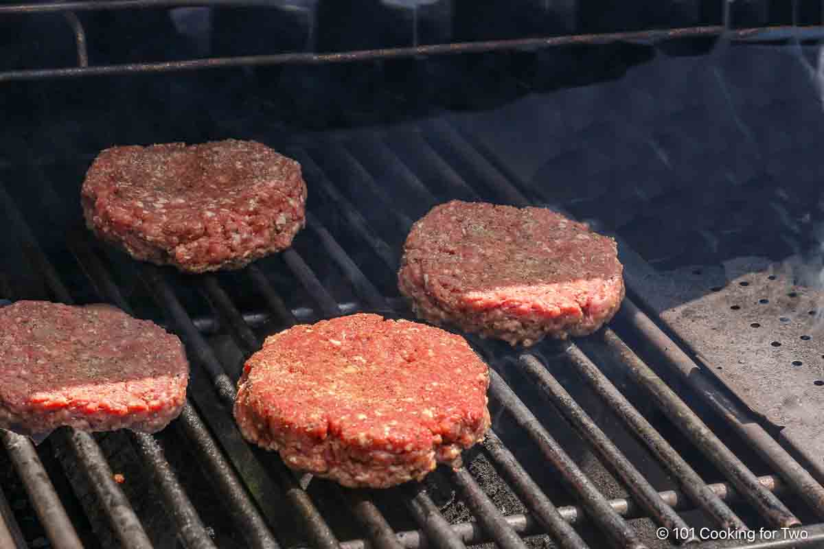 raw burger patties on the grill.