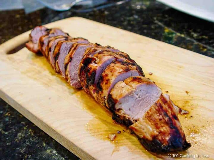 grilled pork tenderloin cut on a board.