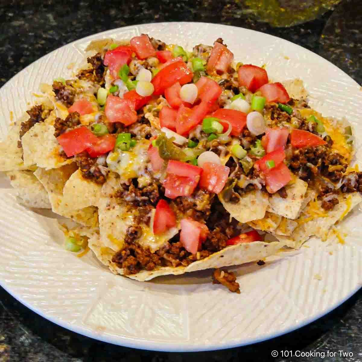 A plate full of ground beef nachos.
