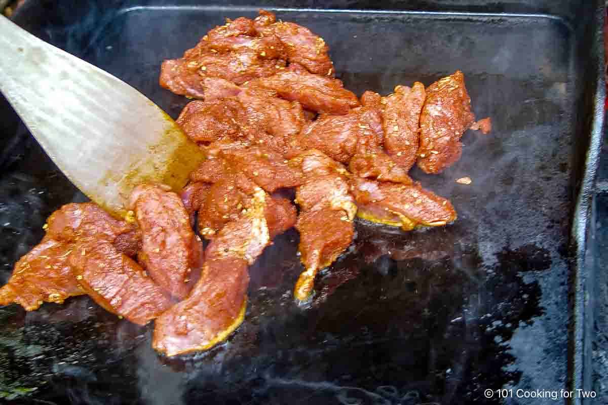 seasoned pork on the griddle.